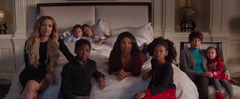 Movie still from “The Best Man Holiday” (2013), directed by Malcolm D. Lee – A group of people sitting on a bed; Wide shot, High angle