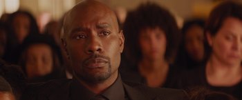 Movie still from “The Best Man Holiday” (2013), directed by Malcolm D. Lee – A person wearing a suit and tie; Close Up shot, Over the shoulder angle