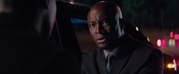 Movie still from “The Best Man Holiday” (2013), directed by Malcolm D. Lee – A man in a suit and tie looking at the camera; Close Up shot, Over the shoulder angle
