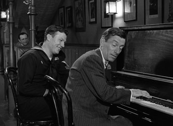 Movie still from “The Best Years of Our Lives” (1946), directed by William Wyler – Two men sitting at a piano in a room; Medium shot, Over the shoulder angle
