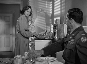 Movie still from “The Best Years of Our Lives” (1946), directed by William Wyler – An old photo of a man and a woman in a kitchen; Medium shot, Over the shoulder angle