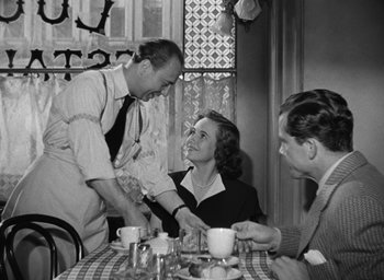 Movie still from “The Best Years of Our Lives” (1946), directed by William Wyler – An old black and white photo of a man and a woman at a table; Medium shot, Over the shoulder angle