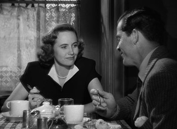 Movie still from “The Best Years of Our Lives” (1946), directed by William Wyler – An old photo of a man and a woman at a dinner table; Medium shot, Over the shoulder angle