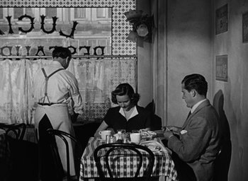 Movie still from “The Best Years of Our Lives” (1946), directed by William Wyler – A man and a woman sitting at a table in a restaurant; Wide shot, High angle