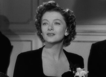 Movie still from “The Best Years of Our Lives” (1946), directed by William Wyler – An old black and white photo of a woman in a black dress; Close Up shot, Over the shoulder angle