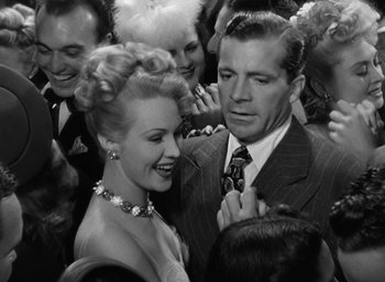 Movie still from “The Best Years of Our Lives” (1946), directed by William Wyler – A man and a woman in a crowd of people; Medium shot, High angle