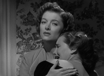 Movie still from “The Best Years of Our Lives” (1946), directed by William Wyler – A woman holding a woman in her arms in front of a wall; Close Up shot, Low angle