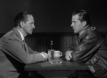 Movie still from “The Best Years of Our Lives” (1946), directed by William Wyler – A couple of men sitting at a table with a drink; Medium shot, Over the shoulder angle