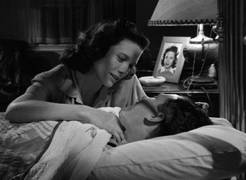 Movie still from “The Best Years of Our Lives” (1946), directed by William Wyler – An old photo of a man and a woman laying in a bed; Medium shot, Low angle