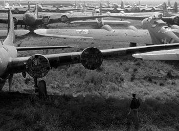 Movie still from “The Best Years of Our Lives” (1946), directed by William Wyler – A man standing in front of a field of airplanes; Extreme Wide shot, High angle