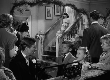 Movie still from “The Best Years of Our Lives” (1946), directed by William Wyler – A black and white photo of people in formal wear; Wide shot, High angle
