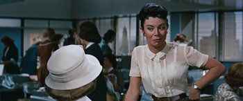 Movie still from “The Best of Everything” (1959), directed by Jean Negulesco – A woman wearing a white shirt and a white hat; Close Up shot, Over the shoulder angle