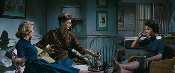 Movie still from “The Best of Everything” (1959), directed by Jean Negulesco – A woman pouring a glass of wine into a teapot; Medium shot, High angle