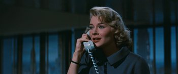 Movie still from “The Best of Everything” (1959), directed by Jean Negulesco – A woman talking on a phone while sitting down; Close Up shot, Low angle