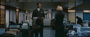 Movie still from “The Best of Everything” (1959), directed by Jean Negulesco – A man in a black suit and a woman in a black suit; Medium shot, Over the shoulder angle