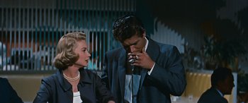 Movie still from “The Best of Everything” (1959), directed by Jean Negulesco – A man and a woman are smoking a cigarette together; Medium shot, Low angle