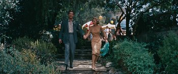 Movie still from “The Best of Everything” (1959), directed by Jean Negulesco – A man and a woman holding hands while walking down steps; Wide shot, High angle