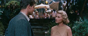 Movie still from “The Best of Everything” (1959), directed by Jean Negulesco – A man and a woman standing next to each other in front of an umbrella; Medium shot, Over the shoulder angle