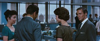 Movie still from “The Best of Everything” (1959), directed by Jean Negulesco – A man and a woman standing next to each other in an office; Medium shot, Over the shoulder angle
