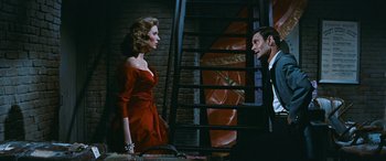 Movie still from “The Best of Everything” (1959), directed by Jean Negulesco – A man and a woman standing next to each other on stairs; Medium shot, Low angle