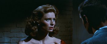 Movie still from “The Best of Everything” (1959), directed by Jean Negulesco – A woman in a red dress looking to her left; Close Up shot, Over the shoulder angle