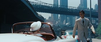 Movie still from “The Best of Everything” (1959), directed by Jean Negulesco – A woman in a white hat driving a car in the city; Wide shot, Low angle