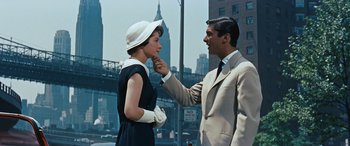 Movie still from “The Best of Everything” (1959), directed by Jean Negulesco – A man and a woman are standing next to each other in front of a bridge; Medium shot, Over the shoulder angle