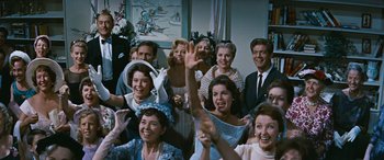 Movie still from “The Best of Everything” (1959), directed by Jean Negulesco – A group of people that are standing in a room together; Medium shot, Low angle