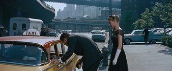Movie still from “The Best of Everything” (1959), directed by Jean Negulesco – A man and a woman looking into a yellow car; Medium shot, Over the shoulder angle