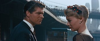Movie still from “The Best of Everything” (1959), directed by Jean Negulesco – A man and a woman standing next to each other on a bridge; Close Up shot, Over the shoulder angle