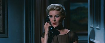 Movie still from “The Best of Everything” (1959), directed by Jean Negulesco – A woman talking on a phone while wearing a black dress; Close Up shot, Low angle