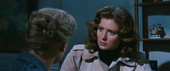 Movie still from “The Best of Everything” (1959), directed by Jean Negulesco – A woman in a trench coat looking at another woman in a black jacket; Close Up shot, Over the shoulder angle