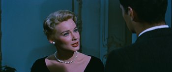 Movie still from “The Best of Everything” (1959), directed by Jean Negulesco – A woman in a black dress with a pearl necklace; Close Up shot, Over the shoulder angle
