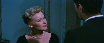 Movie still from “The Best of Everything” (1959), directed by Jean Negulesco – A woman in a black dress with a pearl necklace; Close Up shot, Over the shoulder angle