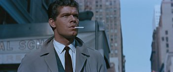 Movie still from “The Best of Everything” (1959), directed by Jean Negulesco – A man wearing a suit and tie smoking a cigarette; Close Up shot, Low angle