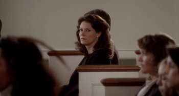 Movie still from “The Big Chill” (1983), directed by Lawrence Kasdan – A woman sitting in a pew in a church; Close Up shot, Over the shoulder angle
