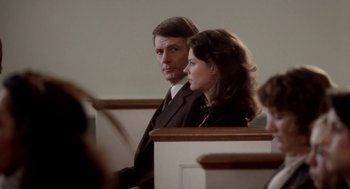 Movie still from “The Big Chill” (1983), directed by Lawrence Kasdan – A man and a woman sitting next to each other in church pews; Medium shot, Over the shoulder angle