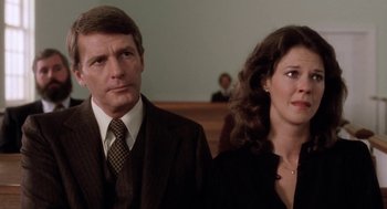 Movie still from “The Big Chill” (1983), directed by Lawrence Kasdan – A man and a woman standing next to each other in a courtroom; Close Up shot, Low angle