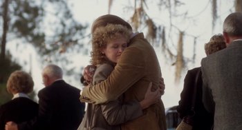 Movie still from “The Big Chill” (1983), directed by Lawrence Kasdan – Two people hugging each other in a park; Medium shot, Over the shoulder angle