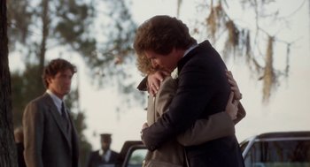 Movie still from “The Big Chill” (1983), directed by Lawrence Kasdan – A couple of people that are hugging each other; Close Up shot, Over the shoulder angle
