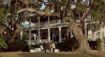 Movie still from “The Big Chill” (1983), directed by Lawrence Kasdan – Two people standing on the front steps of a large house; Extreme Wide shot, Low angle