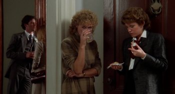 Movie still from “The Big Chill” (1983), directed by Lawrence Kasdan – A woman drinking a cup of coffee while another woman looks on; Medium shot, Over the shoulder angle