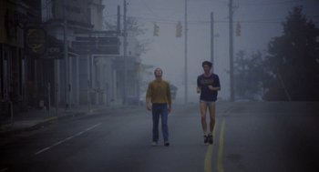 Movie still from “The Big Chill” (1983), directed by Lawrence Kasdan – Two men walking down a street in the fog; Wide shot, Low angle