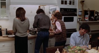 Movie still from “The Big Chill” (1983), directed by Lawrence Kasdan – A group of people standing in a kitchen preparing a meal; Wide shot, High angle