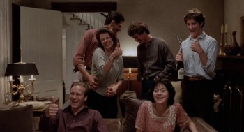 Movie still from “The Big Chill” (1983), directed by Lawrence Kasdan – A group of people sitting around a living room together; Medium shot, High angle