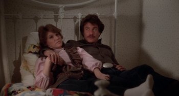 Movie still from “The Big Chill” (1983), directed by Lawrence Kasdan – A man and a woman sitting on a bed together; Medium shot, High angle