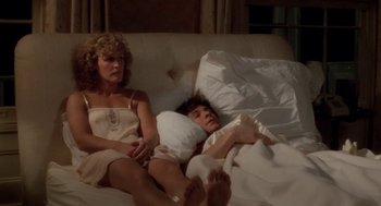 Movie still from “The Big Chill” (1983), directed by Lawrence Kasdan – A man and a woman laying in a bed together; Medium shot, High angle