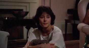 Movie still from “The Big Chill” (1983), directed by Lawrence Kasdan – A woman sitting on the floor holding a pillow in her lap; Close Up shot, Low angle