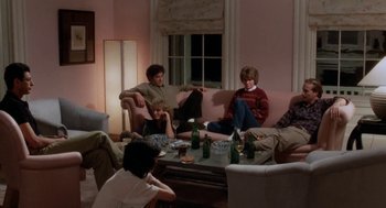 Movie still from “The Big Chill” (1983), directed by Lawrence Kasdan – A group of people sitting around a living room table; Wide shot, High angle