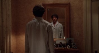 Movie still from “The Big Chill” (1983), directed by Lawrence Kasdan – A man standing in front of a mirror looking at himself in the mirror; Medium shot, Low angle